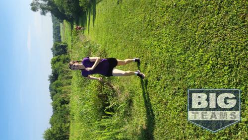 One girl running uphill on grass.