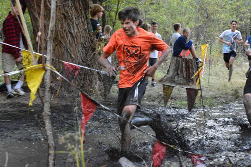 LHS male cross country runner running through mud
